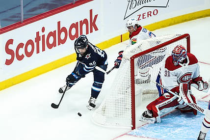 Mar 15, 2021; Winnipeg, Manitoba, CAN; Winnipeg Jets forward Matthieu Perreault (85) skates away from Montreal Canadiens defenseman Alexander Romanov (27) during the third period at Bell MTS Place. Mandatory Credit: Terrence Lee-USA TODAY Sports