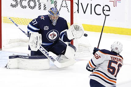 Apr 17, 2021; Winnipeg, Manitoba, CAN; Edmonton Oilers right wing Kailer Yamamoto (56) shoots on Winnipeg Jets goaltender Connor Hellebuyck (37) in the first period at Bell MTS Place. Mandatory Credit: James Carey Lauder-USA TODAY Sports