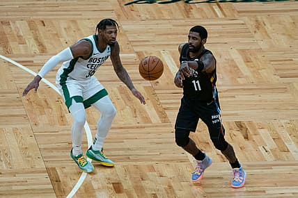 Dec 25, 2020; Boston, Massachusetts, USA;  Brooklyn Nets point guard Kyrie Irving (11) passes the ball with Boston Celtics point guard Marcus Smart (36) defending during the third quarter at TD Garden. Mandatory Credit: Gregory Fisher-USA TODAY Sports