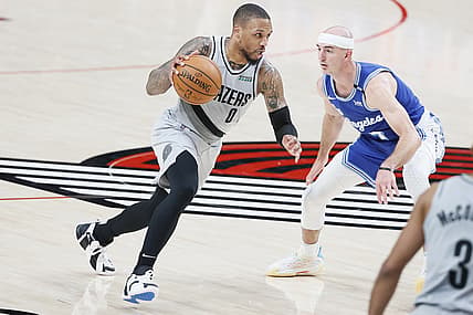 May 7, 2021; Portland, Oregon, USA; Portland Trail Blazers point guard Damian Lillard (0) dribbles the ball as Los Angeles Lakers shooting guard Alex Caruso (right) defends during the second half at Moda Center. Mandatory Credit: Soobum Im-USA TODAY Sports