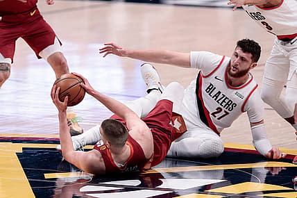 May 24, 2021; Denver, Colorado, USA; Denver Nuggets center Nikola Jokic (15) looks to pass the ball as he battles on the ground with Portland Trail Blazers center Jusuf Nurkic (27) in the first quarter during game two in the first round of the 2021 NBA Playoffs at Ball Arena. Mandatory Credit: Isaiah J. Downing-USA TODAY Sports