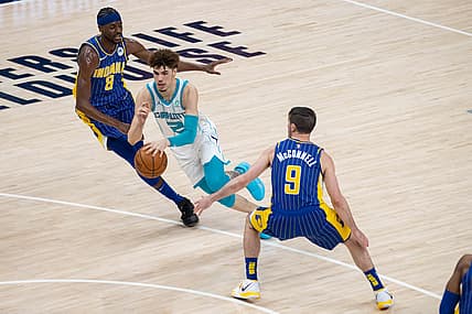 May 18, 2021; Indianapolis, Indiana, USA; Charlotte Hornets guard LaMelo Ball (2) dribbles the ball while Indiana Pacers forward Justin Holiday (8) defends  in the third quarter at Bankers Life Fieldhouse. Mandatory Credit: Trevor Ruszkowski-USA TODAY Sports