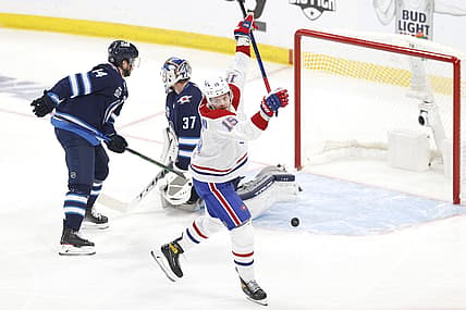 Jun 2, 2021; Winnipeg, Manitoba, CAN; Montreal Canadiens center Jesperi Kotkaniemi (15) scores a first period goal against Winnipeg Jets goaltender Connor Hellebuyck (37) in game one of the second round of the 2021 Stanley Cup Playoffs at Bell MTS Place. Mandatory Credit: James Carey Lauder-USA TODAY Sports