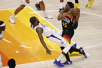 Jun 8, 2021; Salt Lake City, Utah, USA; Utah Jazz guard Donovan Mitchell (45) drives into LA Clippers guard Paul George (13) drawing the foul in the first quarter during game one in the second round of the 2021 NBA Playoffs. at Vivint Arena. Mandatory Credit: Jeffrey Swinger-USA TODAY Sports