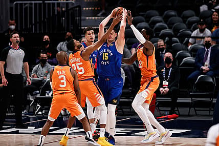 Jun 11, 2021; Denver, Colorado, USA; Denver Nuggets center Nikola Jokic (15) is defended by Phoenix Suns center Deandre Ayton (22) and forward Mikal Bridges (25) as guard Chris Paul (3) and forward Michael Porter Jr. (1) look on in the first quarter during game three in the second round of the 2021 NBA Playoffs at Ball Arena. Mandatory Credit: Isaiah J. Downing-USA TODAY Sports
