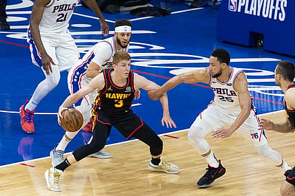Jun 20, 2021; Philadelphia, Pennsylvania, USA; Atlanta Hawks guard Kevin Huerter (3) controls the ball against Philadelphia 76ers guard Ben Simmons (25) and guard Seth Curry (31) during the second quarter of game seven of the second round of the 2021 NBA Playoffs at Wells Fargo Center. Mandatory Credit: Bill Streicher-USA TODAY Sports