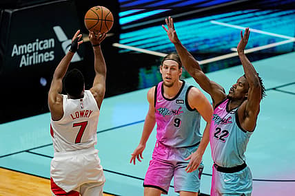 Feb 24, 2021; Miami, Florida, USA; Toronto Raptors guard Kyle Lowry (7) shoots the ball over Miami Heat forward Jimmy Butler (22) and forward Kelly Olynyk (9) during the second half at American Airlines Arena. Mandatory Credit: Jasen Vinlove-USA TODAY Sports