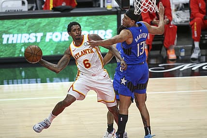 May 13, 2021; Atlanta, Georgia, USA; Atlanta Hawks guard Lou Williams (6) passes the ball around Orlando Magic guard R.J. Hampton (13) during the fourth quarter at State Farm Arena. Mandatory Credit: Brett Davis-USA TODAY Sports