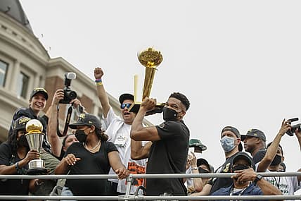 Jul 22, 2021; Milwaukee, WI, USA; Milwaukee Bucks forward Giannis Antetokounmpo (34) holds the Larry O'Brien NBA Championship Trophy during the Milwaukee Bucks victory parade. Mandatory Credit: Kamil Krzaczynski-USA TODAY Sports