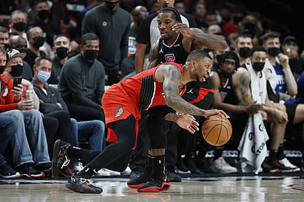 Oct 29, 2021; Portland, Oregon, USA; Portland Trail Blazers point guard Damian Lillard (0) dribbles the ball while defended by LA Clippers shooting guard Eric Bledsoe (12) during the first half at Moda Center. Mandatory Credit: Soobum Im-USA TODAY Sports