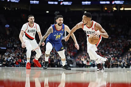 Nov 23, 2021; Portland, Oregon, USA; Portland Trail Blazers shooting guard CJ McCollum (3) dribbles the ball as Denver Nuggets shooting guard Austin Rivers (25) defends during the first half at Moda Center. Mandatory Credit: Soobum Im-USA TODAY Sports