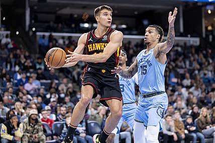 Nov 26, 2021; Memphis, Tennessee, USA; Atlanta Hawks guard Bogdan Bogdanovic (13) looks to pass around Memphis Grizzlies forward Brandon Clarke (15) in the second half at FedExForum. Mandatory Credit: Vasha Hunt-USA TODAY Sports