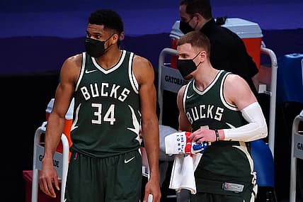 Mar 31, 2021; Los Angeles, California, USA; Milwaukee Bucks forward Giannis Antetokounmpo (34) and guard Donte DiVincenzo (0) watch from the bench wearing face masks  in the second halfagainst the Los Angeles Lakers  at Staples Center. Mandatory Credit: Kirby Lee-USA TODAY Sports
