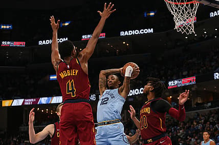Oct 20, 2021; Memphis, Tennessee, USA; Memphis Grizzles guard Ja Morant (12) passes the ball as Cleveland Cavaliers center Evan Mobley (4) and  guard Darius Garland (10) defend during the second half at FedExForum. Mandatory Credit: Petre Thomas-USA TODAY Sports