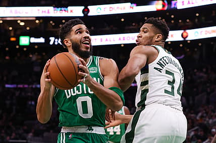 Dec 13, 2021; Boston, Massachusetts, USA; Boston Celtics forward Jayson Tatum (left) drives to the basket while defended by Milwaukee Bucks forward Giannis Antetokounmpo (right) during the first half at TD Garden.