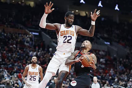 Dec 14, 2021; Portland, Oregon, USA; Portland Trail Blazers point guard Damian Lillard (0) drives to the basket against Phoenix Suns center Deandre Ayton (22) during the second half at Moda Center. Mandatory Credit: Soobum Im-USA TODAY Sports