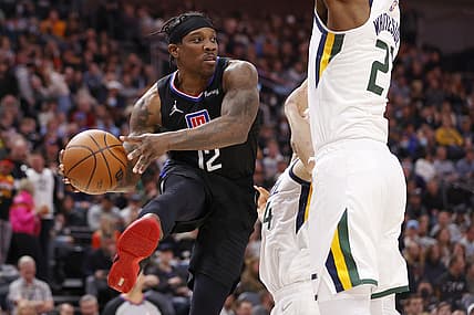 Dec 15, 2021; Salt Lake City, Utah, USA; LA Clippers guard Eric Bledsoe (12) looks to pass against Utah Jazz forward Bojan Bogdanovic (44) and center Hassan Whiteside (21) in the third quarter at Vivint Arena. Mandatory Credit: Jeffrey Swinger-USA TODAY Sports