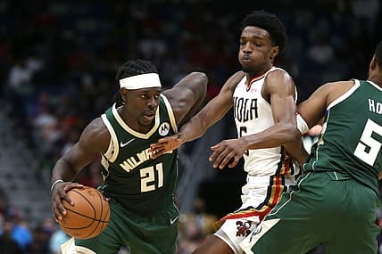 Dec 17, 2021; New Orleans, Louisiana, USA; Milwaukee Bucks guard Jrue Holiday (21) drives around New Orleans Pelicans forward Herbert Jones (5) in the second half at the Smoothie King Center. Mandatory Credit: Chuck Cook-USA TODAY Sports