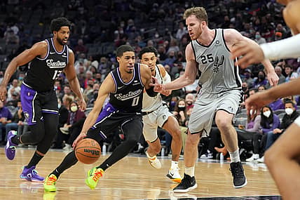Dec 19, 2021; Sacramento, California, USA; Sacramento Kings guard Tyrese Haliburton (0) dribbles the ball while defended by San Antonio Spurs center Jakob Poeltl (25) during the fourth quarter at Golden 1 Center. Mandatory Credit: Darren Yamashita-USA TODAY Sports