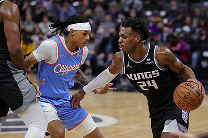 Dec 22, 2021; Sacramento, California, USA; Sacramento Kings guard Buddy Hield (24) dribbles the ball against Los Angeles Clippers guard Brandon Boston Jr. (4) during the first quarter at Golden 1 Center. Mandatory Credit: Sergio Estrada-USA TODAY Sports