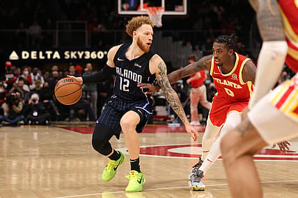 Dec 22, 2021; Atlanta, Georgia, USA; Orlando Magic guard Hassani Gravett (12) drives against Atlanta Hawks guard Delon Wright (0) during the second half at State Farm Arena. Mandatory Credit: Jason Getz-USA TODAY Sports