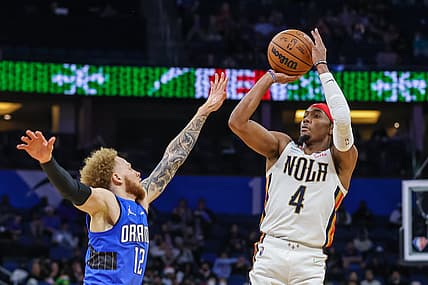 Dec 23, 2021; Orlando, Florida, USA; New Orleans Pelicans guard Devonte' Graham (4) shoots the ball against Orlando Magic guard Hassani Gravett (12) during the second half at Amway Center. Mandatory Credit: Mike Watters-USA TODAY Sports