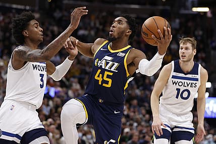 Dec 23, 2021; Salt Lake City, Utah, USA; Utah Jazz guard Donovan Mitchell (45) drives against Minnesota Timberwolves forward Jaden McDaniels (3) and forward Jake Layman (10) in the third quarter at Vivint Arena. Mandatory Credit: Jeffrey Swinger-USA TODAY Sports