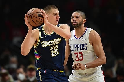 Dec 26, 2021; Los Angeles, California, USA; Denver Nuggets center Nikola Jokic (15) controls the ball against Los Angeles Clippers forward Nicolas Batum (33)  during the first half at Crypto.com Arena. Mandatory Credit: Gary A. Vasquez-USA TODAY Sports
