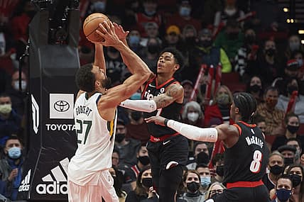 Dec 29, 2021; Portland, Oregon, USA; Portland Trail Blazers guard Anfernee Simons (1) fouls Utah Jazz center Rudy Gobert (27) during the first half at Moda Center. Mandatory Credit: Troy Wayrynen-USA TODAY Sports