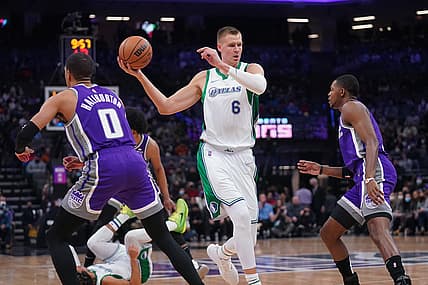 Dec 29, 2021; Sacramento, California, USA; Dallas Mavericks center Kristaps Porzingis (6) holds onto the ball between Sacramento Kings guard Tyrese Haliburton (0) and guard De'Aaron Fox (5) in the first quarter at the Golden 1 Center. Mandatory Credit: Cary Edmondson-USA TODAY Sports