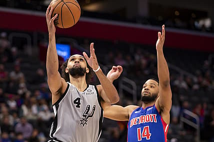 Jan 1, 2022; Detroit, Michigan, USA; San Antonio Spurs guard Derrick White (4) goes up for a shot against Detroit Pistons guard Cassius Stanley (14) during the first quarter at Little Caesars Arena. Mandatory Credit: Raj Mehta-USA TODAY Sports