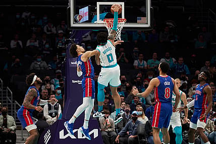 Jan 5, 2022; Charlotte, North Carolina, USA; Charlotte Hornets forward Miles Bridges (0) dunks over Detroit Pistons guard Cade Cunningham (2) during first quarter action at Spectrum Center. Mandatory Credit: Brian Westerholt-USA TODAY Sports