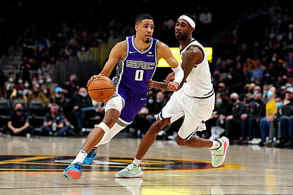 Jan 7, 2022; Denver, Colorado, USA; Sacramento Kings guard Tyrese Haliburton (0) drives past Denver Nuggets forward Will Barton (5) in the second quarter at Ball Arena. Mandatory Credit: Ron Chenoy-USA TODAY Sports