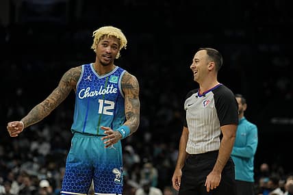 Jan 8, 2022; Charlotte, North Carolina, USA; Charlotte Hornets guard Kelly Oubre Jr. (12) talks with official Kane Fitzgerald (5) during the second half against the Milwaukee Bucks at the Spectrum Center. Mandatory Credit: Jim Dedmon-USA TODAY Sports