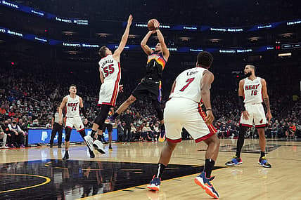 Jan 8, 2022; Phoenix, Arizona, USA; Phoenix Suns guard Devin Booker (1) shoots over Miami Heat guard Duncan Robinson (55) during the first half at Footprint Center. Mandatory Credit: Joe Camporeale-USA TODAY Sports