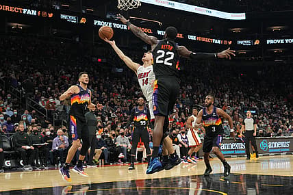 Jan 8, 2022; Phoenix, Arizona, USA; Miami Heat guard Tyler Herro (14) puts up a layup over Phoenix Suns center Deandre Ayton (22) during the second half at Footprint Center. Mandatory Credit: Joe Camporeale-USA TODAY Sports