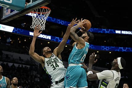 Jan 10, 2022; Charlotte, North Carolina, USA; Charlotte Hornets forward Miles Bridges (0) takes a jump shot defended by Milwaukee Bucks forward Giannis Antetokounmpo (34) during the second quarter at the Spectrum Center. Mandatory Credit: Jim Dedmon-USA TODAY Sports
