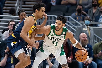Jan 12, 2022; Indianapolis, Indiana, USA; Boston Celtics forward Jayson Tatum (0) dribbles the ball while Indiana Pacers guard Malcolm Brogdon (7) defends in the first quarter at Gainbridge Fieldhouse. Mandatory Credit: Trevor Ruszkowski-USA TODAY Sports