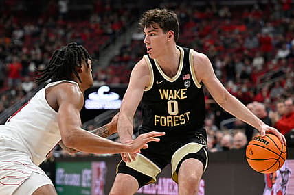 Dec 29, 2021; Louisville, Kentucky, USA;  Wake Forest Demon Deacons forward Jake LaRavia (0) dribbles against Louisville Cardinals guard Dre Davis (14) during the first half at KFC Yum! Center. Louisville defeated Wake Forest 73-69. Mandatory Credit: Jamie Rhodes-USA TODAY Sports