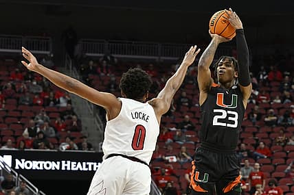 Feb 16, 2022; Louisville, Kentucky, USA;  Miami (Fl) Hurricanes guard Kameron McGusty (23) shoots against Louisville Cardinals guard Noah Locke (0) during the first half at KFC Yum! Center. Miami defeated Louisville 70-63. Mandatory Credit: Jamie Rhodes-USA TODAY Sports