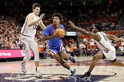 Feb 23, 2022; Auburn, Alabama, USA;  Mississippi Rebels forward Jaemyn Brakefield (4) drives to the goal between Auburn Tigers forward Walker Kessler (13) and guard K.D. Johnson (0) during the first half at Auburn Arena. Mandatory Credit: John Reed-USA TODAY Sports
