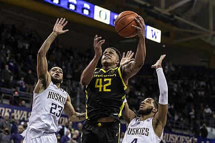 Mar 3, 2022; Seattle, Washington, USA; Oregon Ducks guard Jacob Young (42) drives to the hoop against Washington Huskies guard Terrell Brown Jr. (23) and guard PJ Fuller (4) during the second half at Alaska Airlines Arena at Hec Edmundson Pavilion. Mandatory Credit: Stephen Brashear-USA TODAY Sports