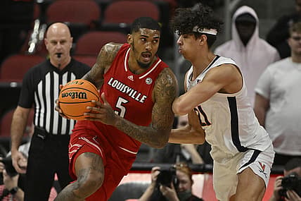 Mar 5, 2022; Louisville, Kentucky, USA;  Louisville Cardinals forward Malik Williams (5) drives to the basket against Virginia Cavaliers forward Kadin Shedrick (21) during the first half at KFC Yum! Center. Mandatory Credit: Jamie Rhodes-USA TODAY Sports