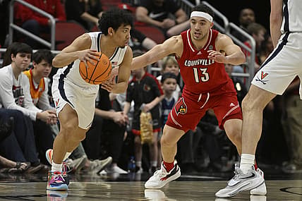 Mar 5, 2022; Louisville, Kentucky, USA;  Virginia Cavaliers guard Kihei Clark (0) dribbles against Louisville Cardinals guard Jarrod West (13) during the second half at KFC Yum! Center. Virginia defeated Louisville 71-61. Mandatory Credit: Jamie Rhodes-USA TODAY Sports