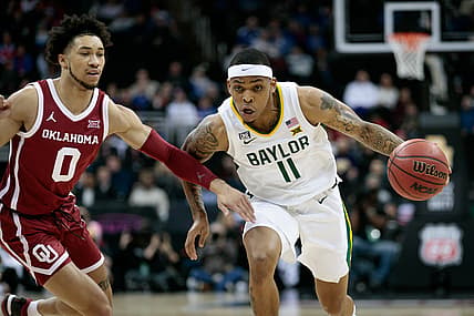 Mar 10, 2022; Kansas City, MO, USA; Baylor Bears guard James Akinjo (11) drives to the basket around Oklahoma Sooners guard Jordan Goldwire (0) during the first half at T-Mobile Center. Mandatory Credit: William Purnell-USA TODAY Sports