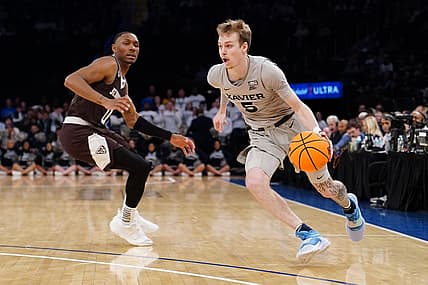 Mar 29, 2022; New York, New York, USA; Xavier Musketeers guard Adam Kunkel (5) dribbles the ball pst St. Bonaventure Bonnies guard Kyle Lofton (0) defending  during the NIT college basketball semifinals at Madison Square Garden. Mandatory Credit: Gregory Fisher-USA TODAY Sports