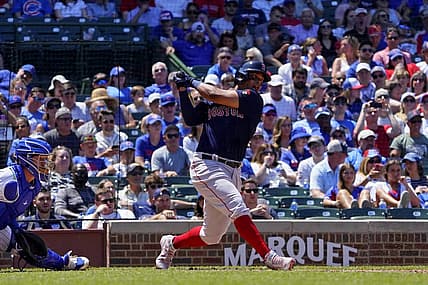 Jul 3, 2022; Chicago, Illinois, USA; Boston Red Sox third baseman Rafael Devers (11) hits an infield single against the Chicago Cubs during the third inning at Wrigley Field. Mandatory Credit: David Banks-USA TODAY Sports