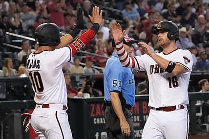 Jul 4, 2022; Phoenix, Arizona, USA; Arizona Diamondbacks third baseman Josh Rojas (10) and catcher Carson Kelly (18) celebrate after scoring runs against the San Francisco Giants during the eighth inning at Chase Field. Mandatory Credit: Joe Camporeale-USA TODAY Sports