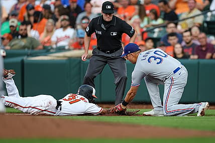 Jul 5, 2022; Baltimore, Maryland, USA; Baltimore Orioles center fielder Cedric Mullins (31) is tagged out by Texas Rangers first baseman Nathaniel Lowe (30) during the first inning at Oriole Park at Camden Yards. Mandatory Credit: Scott Taetsch-USA TODAY Sports