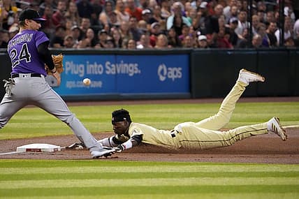 Jul 8, 2022; Phoenix, Arizona, USA; Arizona Diamondbacks shortstop Geraldo Perdomo (2) reaches base safely against Colorado Rockies third baseman Ryan McMahon (24) during the second inning at Chase Field. Mandatory Credit: Joe Camporeale-USA TODAY Sports